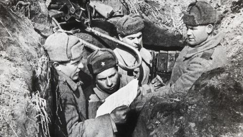 Photo of Russian soldiers in a trench reading a set of papers